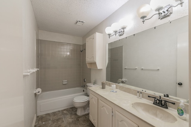 full bathroom with tiled shower / bath combo, vanity, a textured ceiling, and toilet