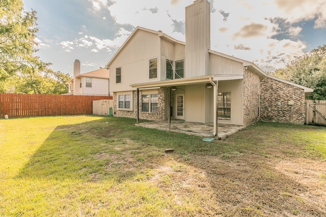 back of property with a patio and a yard