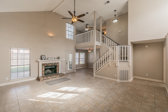 unfurnished living room featuring high vaulted ceiling, beamed ceiling, a wealth of natural light, and a fireplace