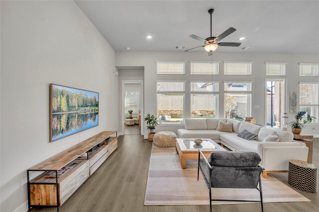 living room with light hardwood / wood-style flooring and ceiling fan