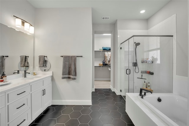 bathroom featuring vanity, shower with separate bathtub, and tile patterned flooring