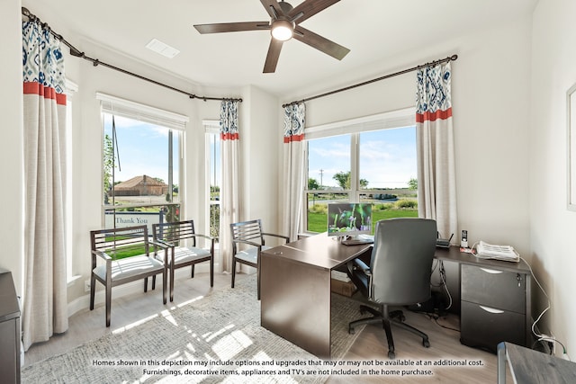 home office with light hardwood / wood-style floors and ceiling fan