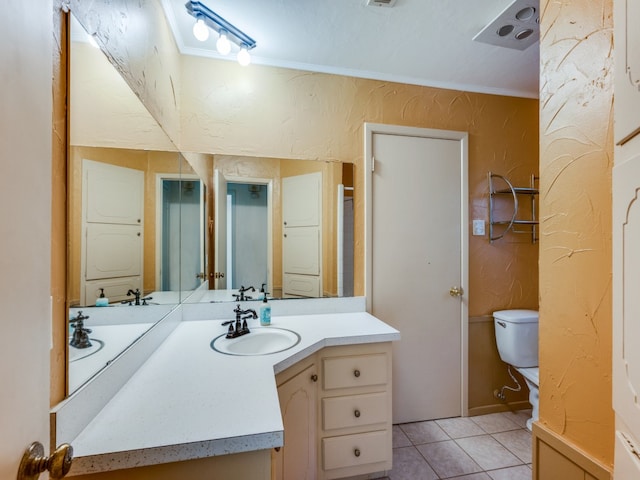 bathroom with toilet, vanity, tile patterned flooring, and ornamental molding