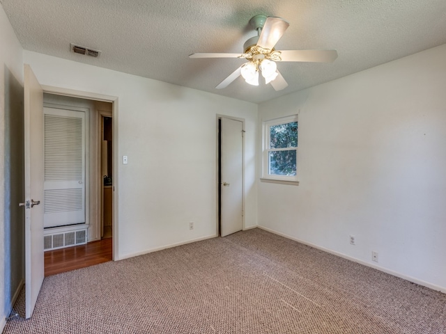 unfurnished bedroom with a textured ceiling, carpet, and ceiling fan