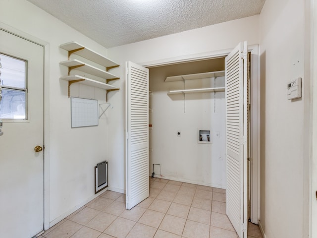 washroom featuring washer hookup, a textured ceiling, electric dryer hookup, and light tile patterned floors