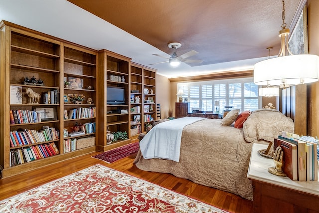 bedroom featuring wood-type flooring, ceiling fan, and a textured ceiling