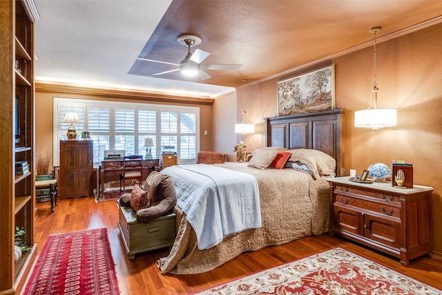 bedroom with hardwood / wood-style floors, ceiling fan, and crown molding