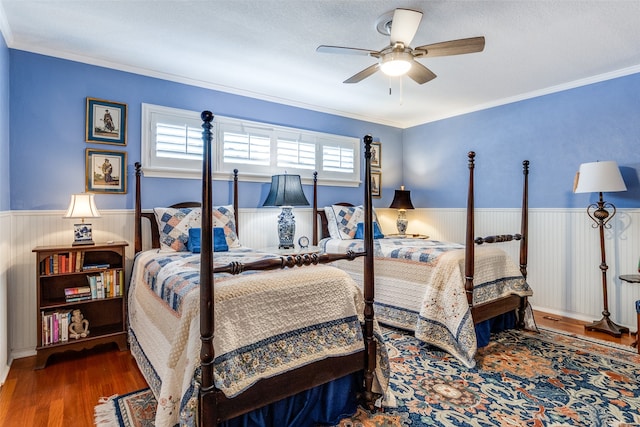 bedroom with hardwood / wood-style flooring, ceiling fan, a textured ceiling, and crown molding