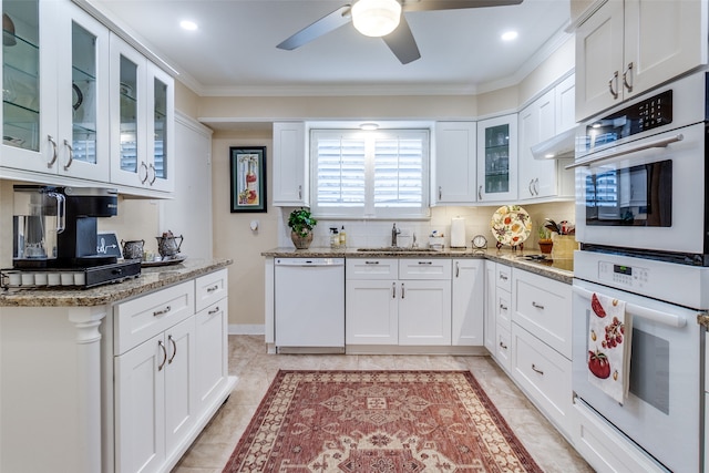 kitchen featuring white appliances, light stone counters, and white cabinets