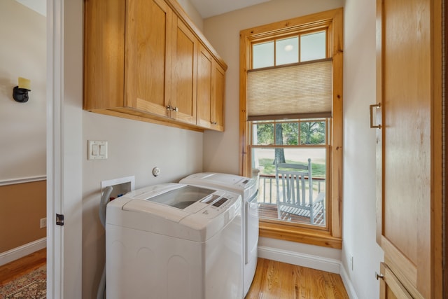 laundry area featuring cabinets, washer and dryer, and light wood-type flooring