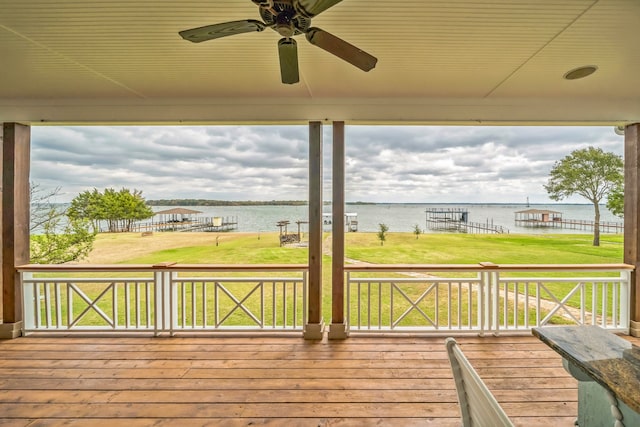 deck with a lawn, ceiling fan, and a water view