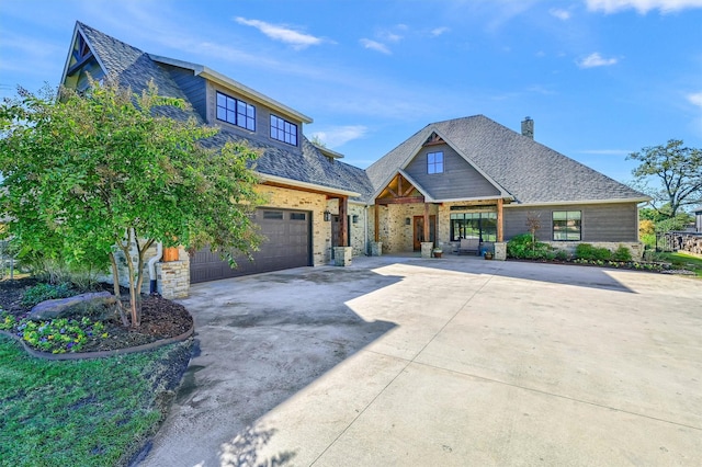 1328 Kiowa Dr E, Gainesville, TX 76240 - view of front facade with driveway, a chimney, stone siding, covered porch, and roof with shingles