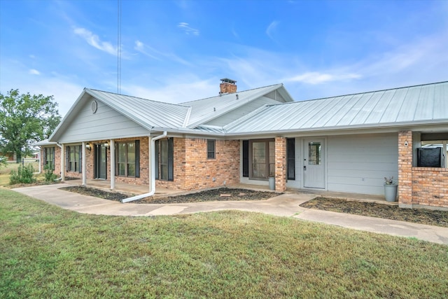 rear view of property with a lawn