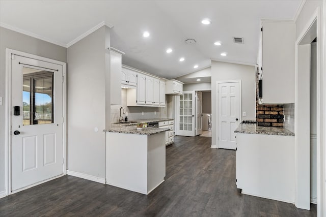 kitchen with white cabinets, dark stone countertops, dark hardwood / wood-style floors, and lofted ceiling