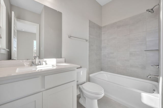 full bathroom featuring tiled shower / bath, vanity, and toilet