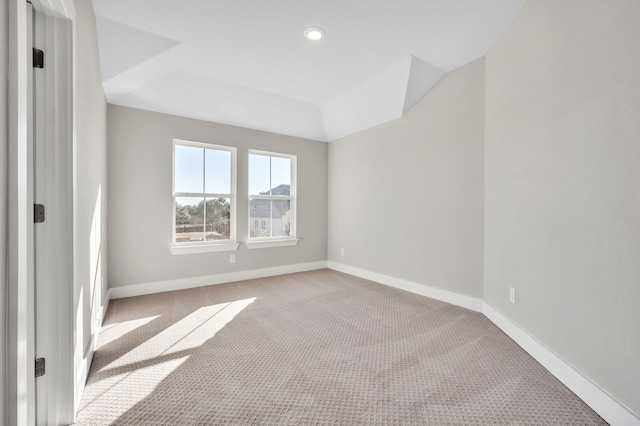 carpeted spare room with a raised ceiling