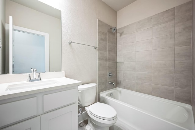 full bathroom with vanity, tiled shower / bath combo, and toilet