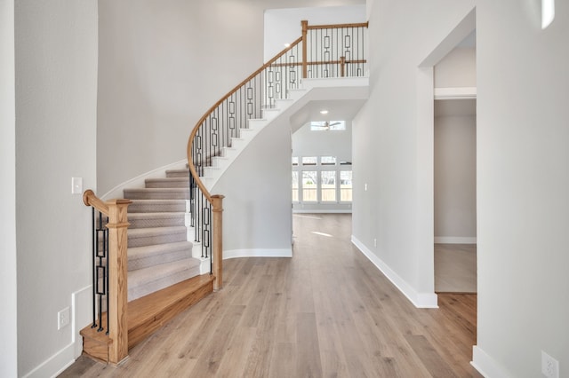 entrance foyer featuring a towering ceiling and light hardwood / wood-style flooring