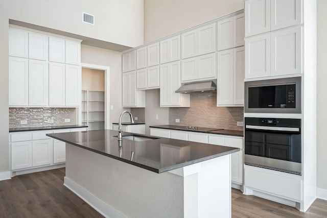 kitchen with white cabinetry, stainless steel oven, and sink