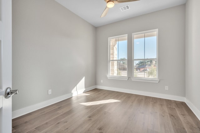 empty room with ceiling fan and light hardwood / wood-style flooring