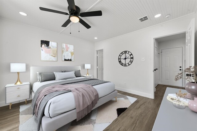 bedroom featuring dark hardwood / wood-style flooring, ornamental molding, and ceiling fan