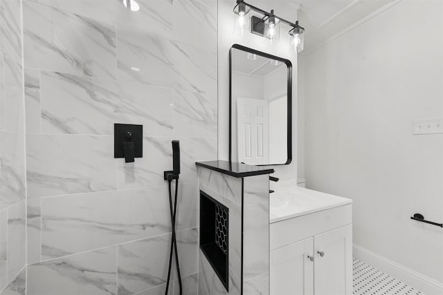 bathroom with tiled shower, ornamental molding, and vanity