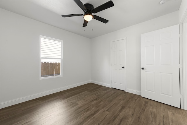 unfurnished bedroom with dark wood-type flooring, ceiling fan, and a closet