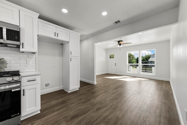 kitchen featuring white cabinetry, appliances with stainless steel finishes, dark hardwood / wood-style flooring, and decorative backsplash