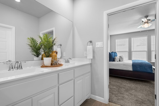 bathroom with hardwood / wood-style floors, ceiling fan, and vanity