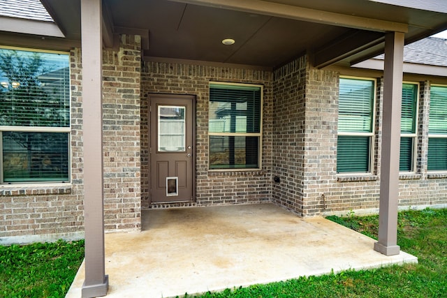 view of exterior entry featuring a patio