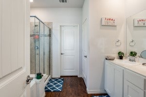 bathroom featuring hardwood / wood-style floors, an enclosed shower, and vanity