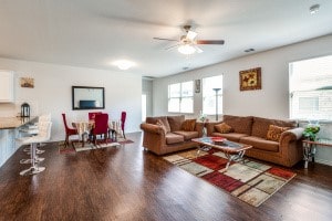 living room with ceiling fan and dark hardwood / wood-style flooring