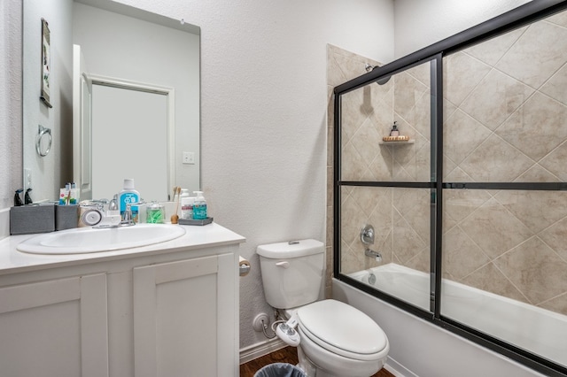 full bathroom featuring bath / shower combo with glass door, vanity, and toilet