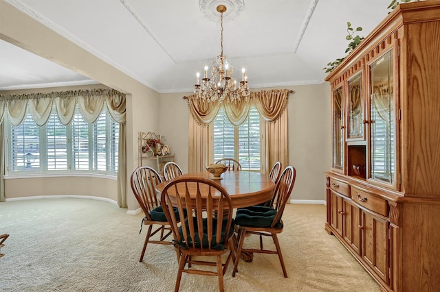 carpeted dining room featuring a notable chandelier and ornamental molding