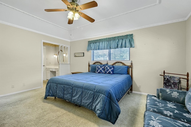 bedroom featuring ensuite bath, ornamental molding, a raised ceiling, carpet floors, and ceiling fan