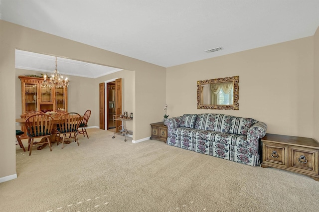 living room with crown molding, carpet, and a notable chandelier