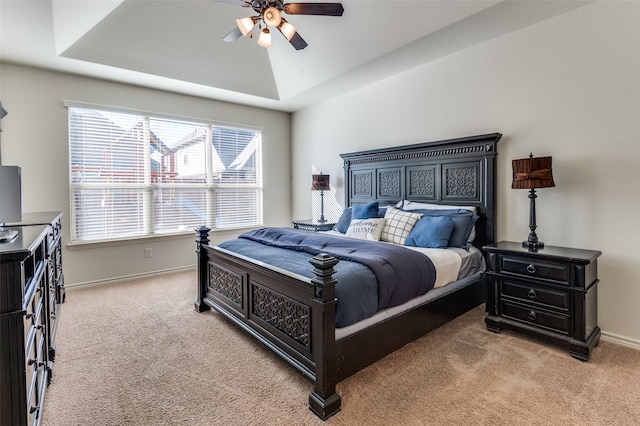 bedroom with ceiling fan, a raised ceiling, lofted ceiling, and light colored carpet