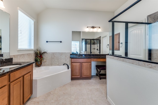 bathroom featuring vanity, shower with separate bathtub, tile patterned flooring, and lofted ceiling