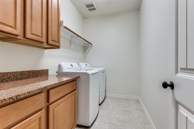 laundry room featuring cabinets, washing machine and dryer, and light tile patterned floors