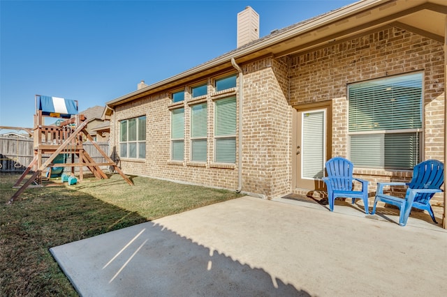 rear view of property with a patio, a playground, and a yard