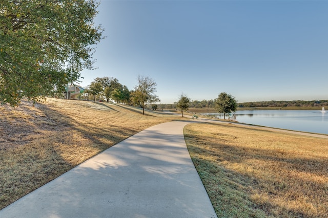 view of property's community featuring a lawn and a water view