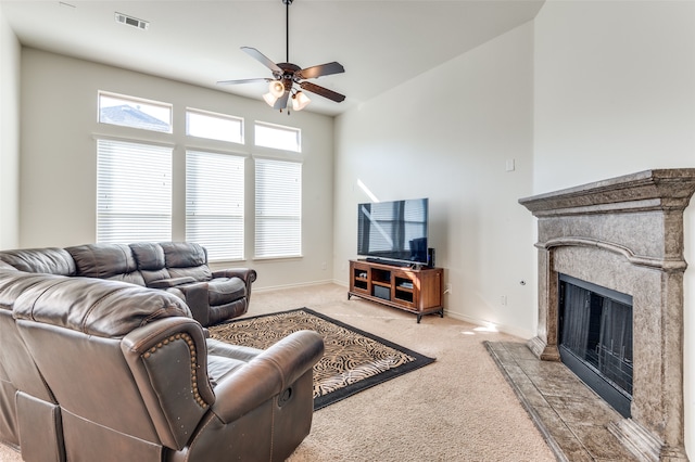 living room with a high ceiling, a wealth of natural light, light colored carpet, and ceiling fan