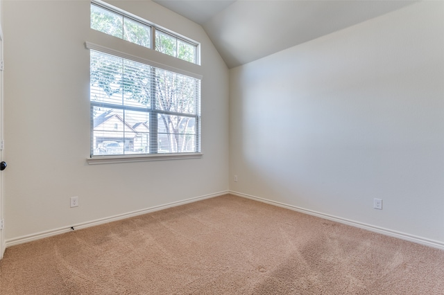 carpeted empty room featuring lofted ceiling