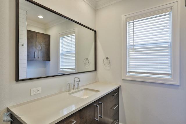 bathroom with vanity, a healthy amount of sunlight, and crown molding