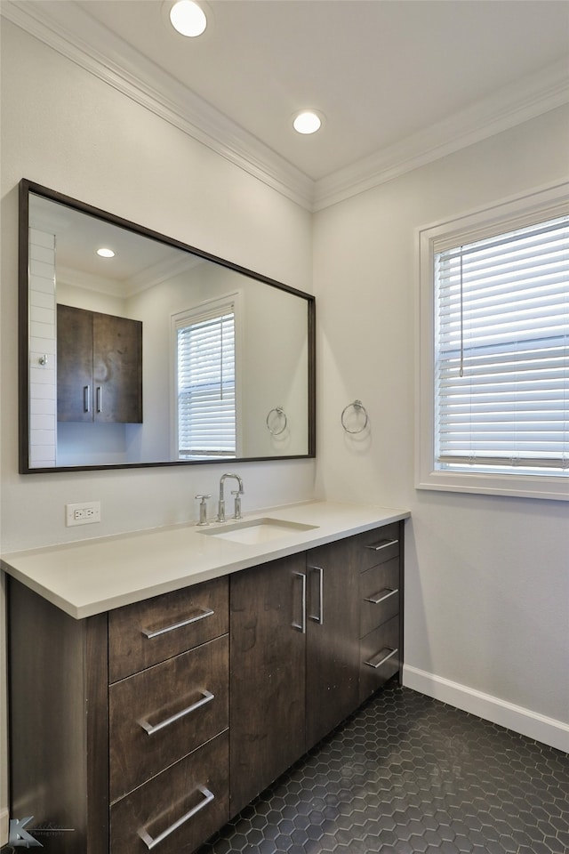 bathroom featuring vanity, a healthy amount of sunlight, tile patterned floors, and ornamental molding