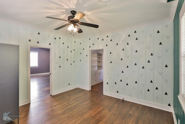 unfurnished room with crown molding, dark hardwood / wood-style floors, and ceiling fan