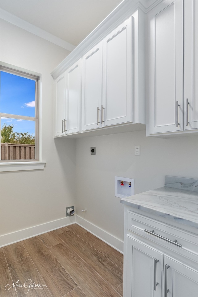 washroom featuring light hardwood / wood-style floors, electric dryer hookup, cabinets, and washer hookup