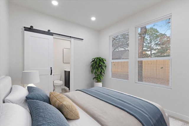 bedroom with connected bathroom and a barn door