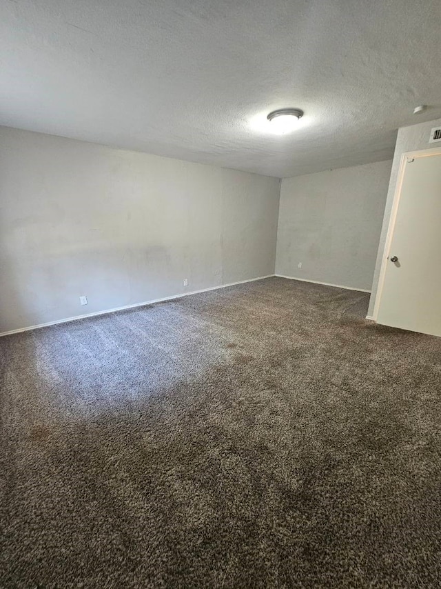 carpeted empty room featuring a textured ceiling