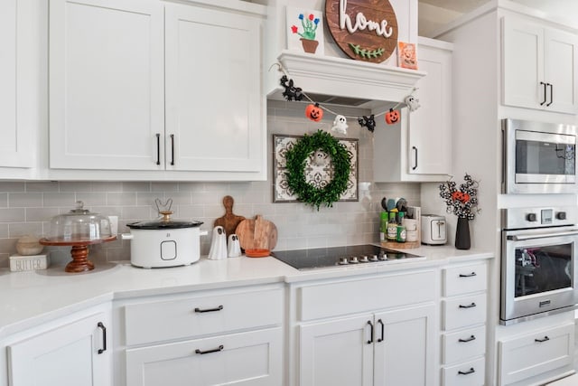 kitchen with white cabinetry, backsplash, and appliances with stainless steel finishes